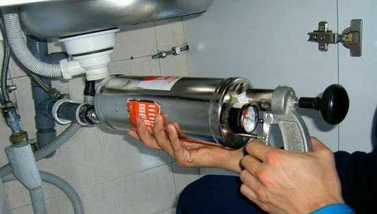 Técnico realizando limpieza de tuberías con mecanismo de sistema de hinchado